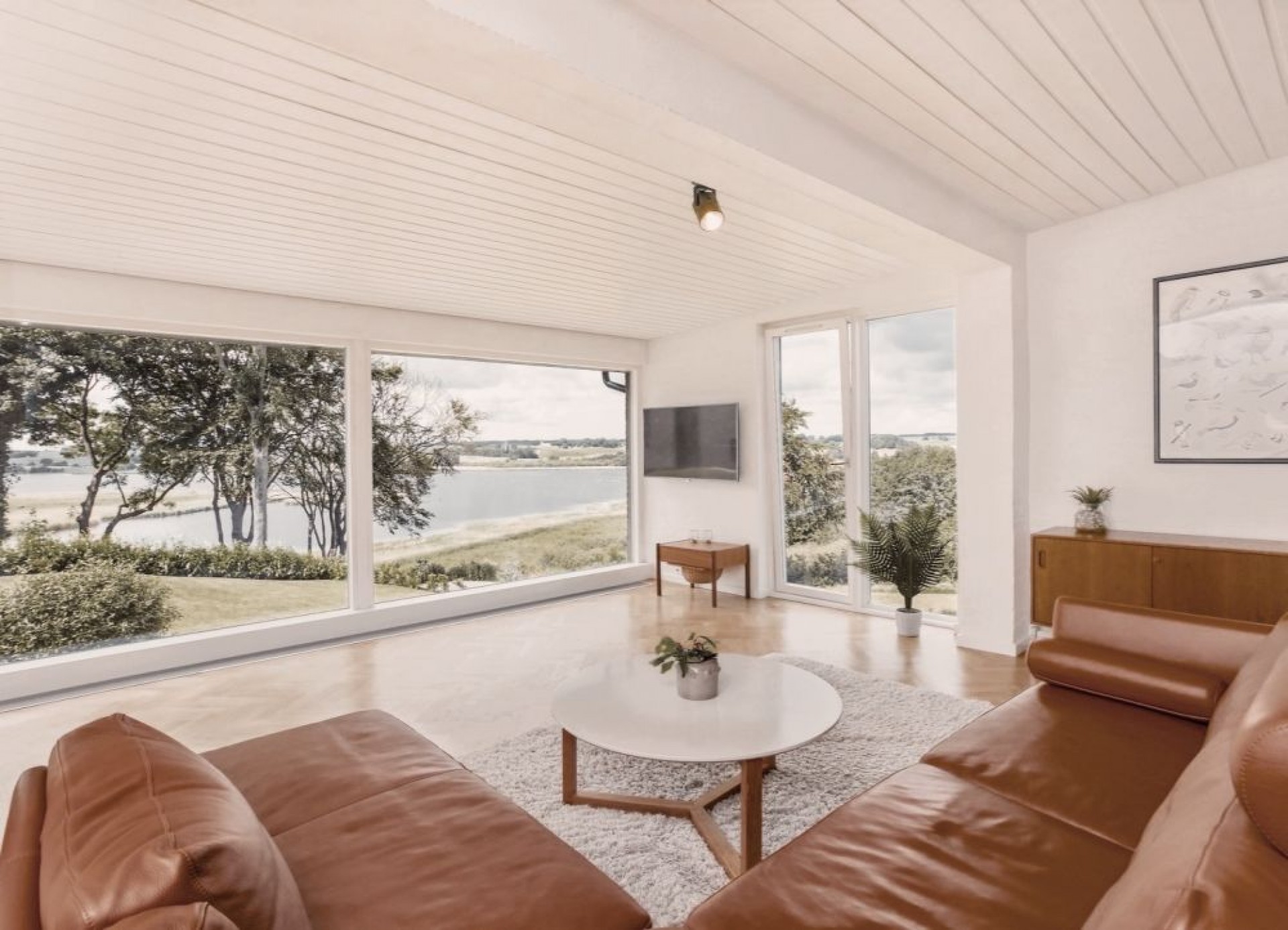 Stue med udsigt over vandet Stue med brun lædersofa og med udsigt over vandet